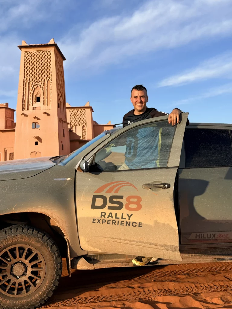 Imagen de un toyota Hilux pick up gris con una kasbah al fondo