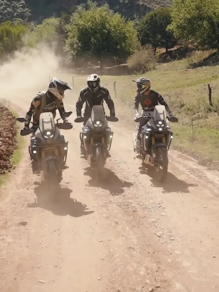 3 motos trail recorriendo un camino de tierra y levantando polvo en el bosque de cedros de Ifrane